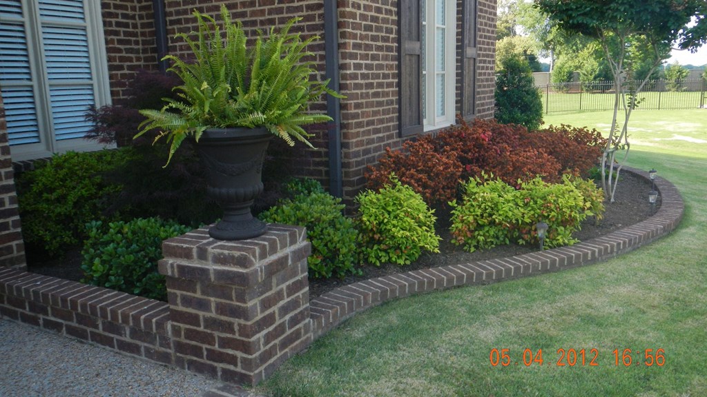 a potted plant sitting on top of a brick retaining wall