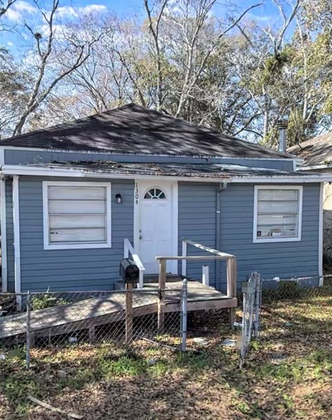 a blue house with a porch and a white door