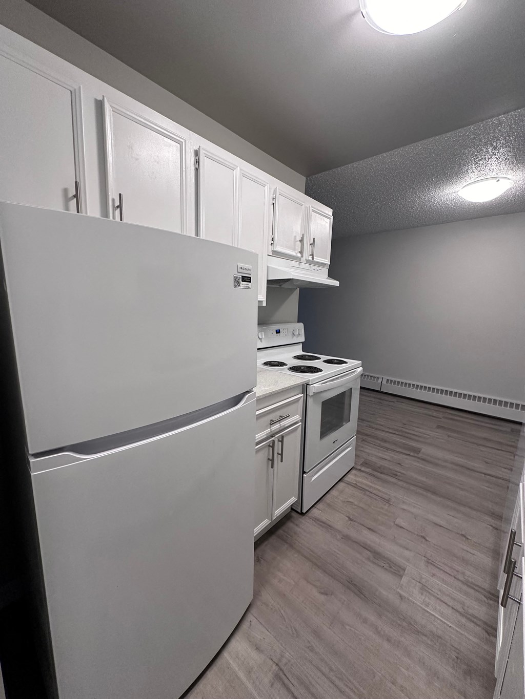 a kitchen with white appliances and white cabinets