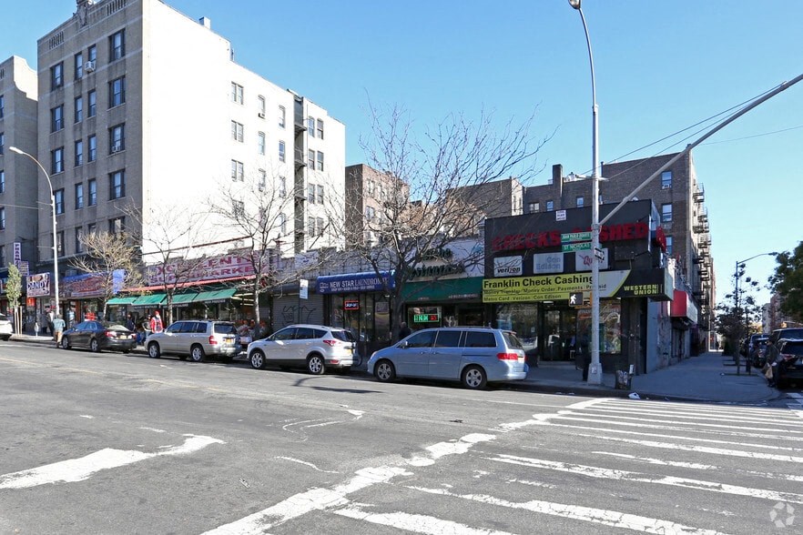 a busy city street with cars parked in front of shops