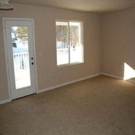 an empty living room with a door and a window