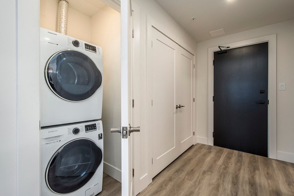 a washer and dryer in a laundry room with a black door