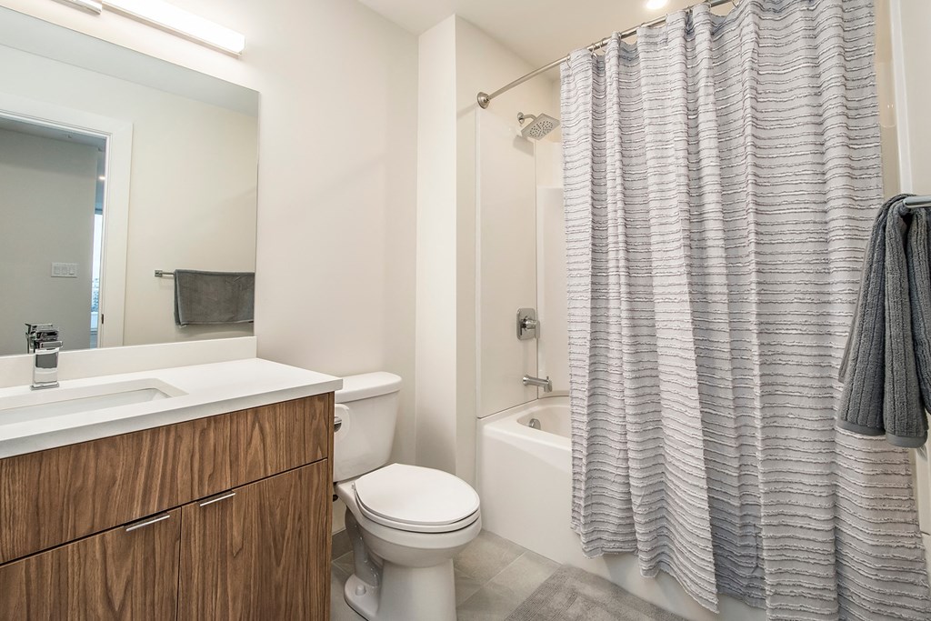 a bathroom with a toilet and a shower and a sink