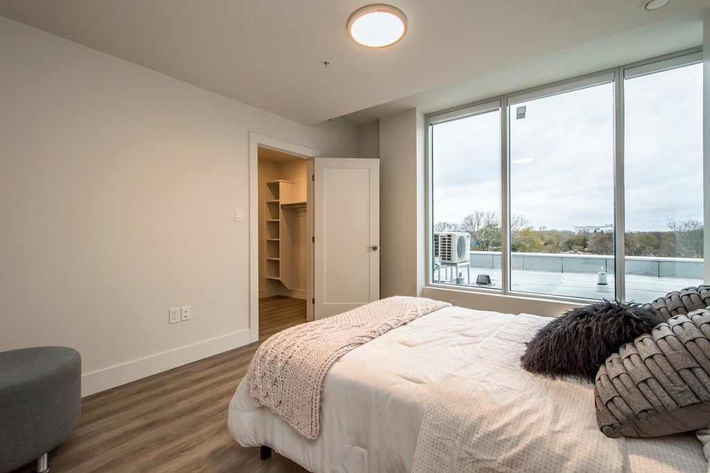 a master bedroom with a large bed and a large window