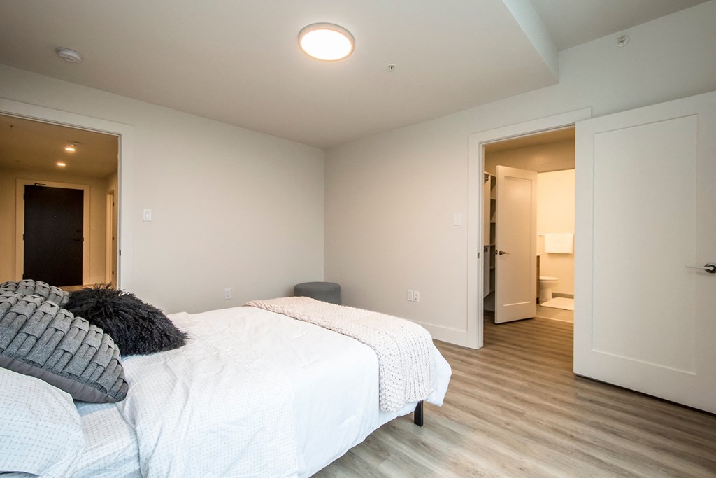 a bedroom with a bed and a door to a bathroom