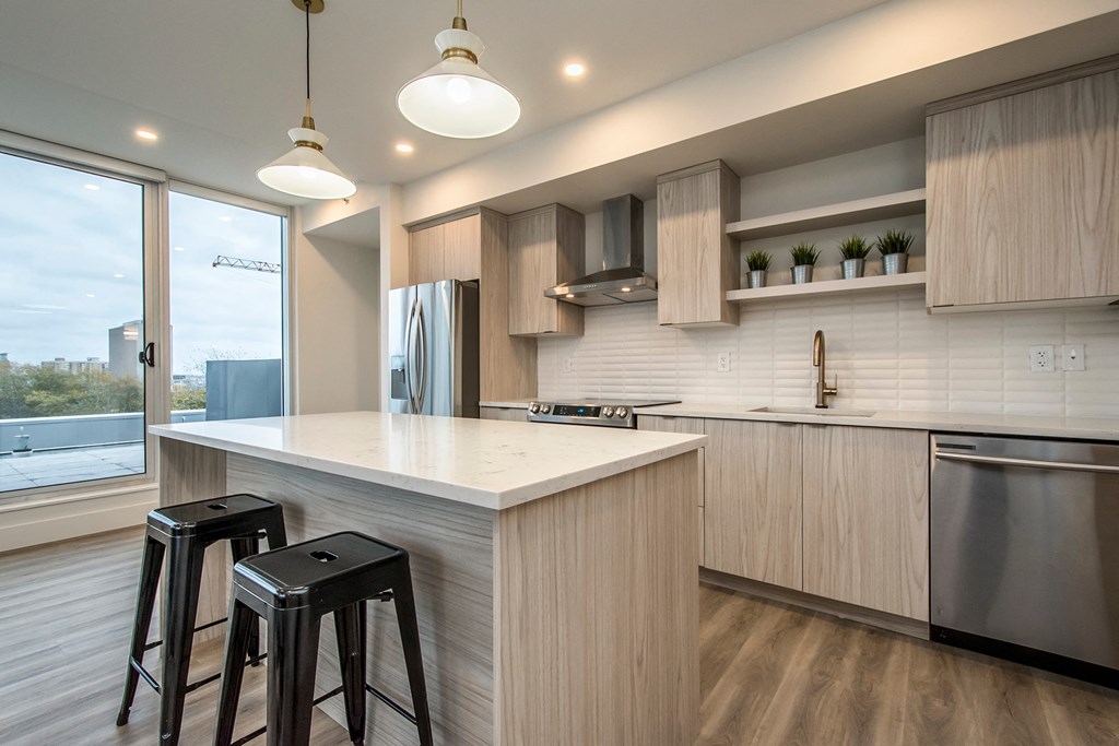 a kitchen with a large island and two stools