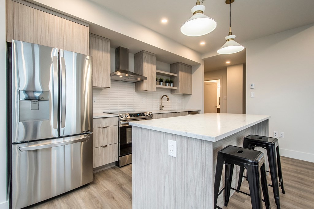 a kitchen with a large island and stainless steel appliances