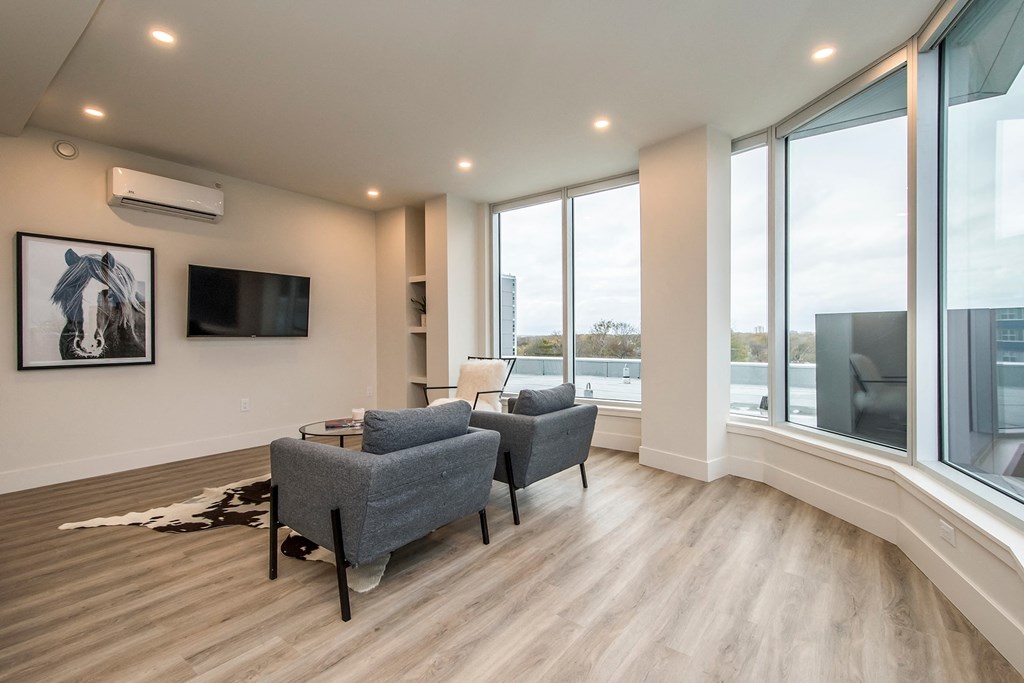 a living room with two couches and a tv and large windows