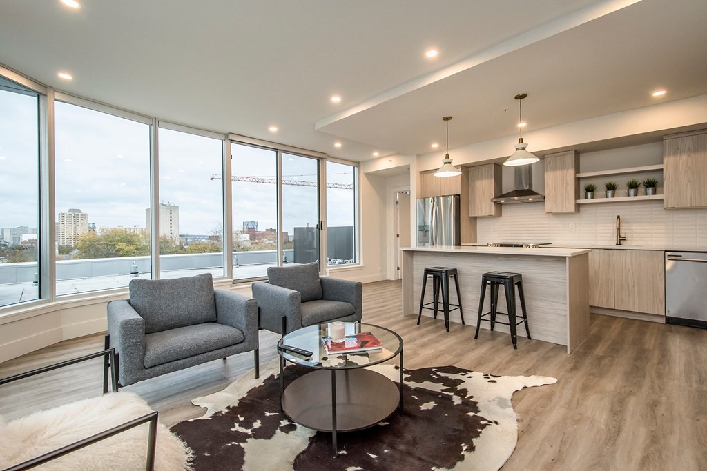 a living room with a kitchen and a large window