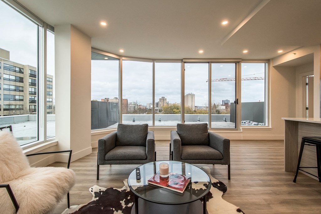 a living room with two chairs and a table and a view of the city
