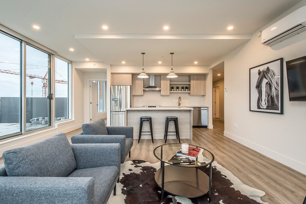 a living room and kitchen with a couch and a table
