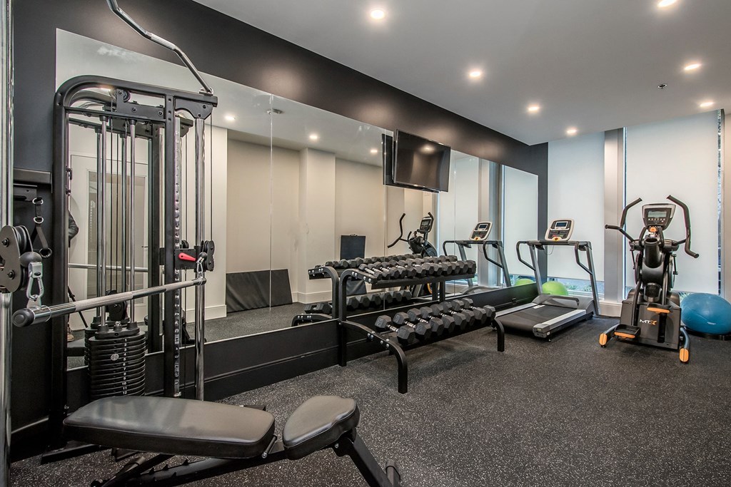 a gym with exercise equipment and weights on the floor