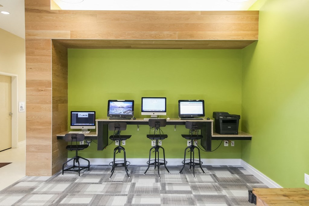 a computer room with four monitors on a table