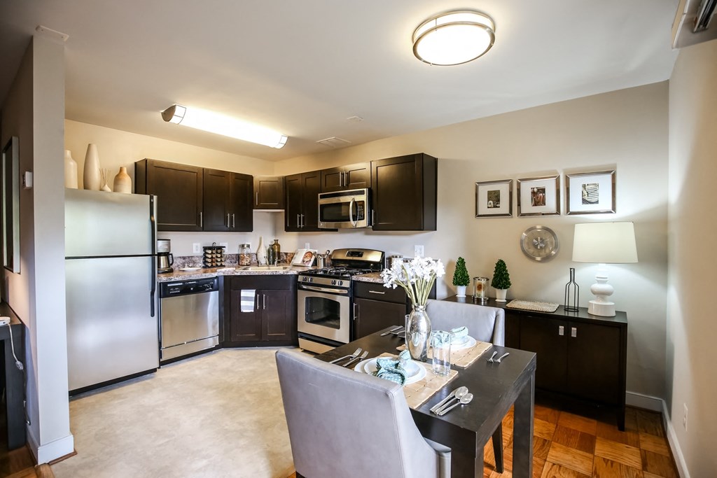 a kitchen with stainless steel appliances and a dining room table
