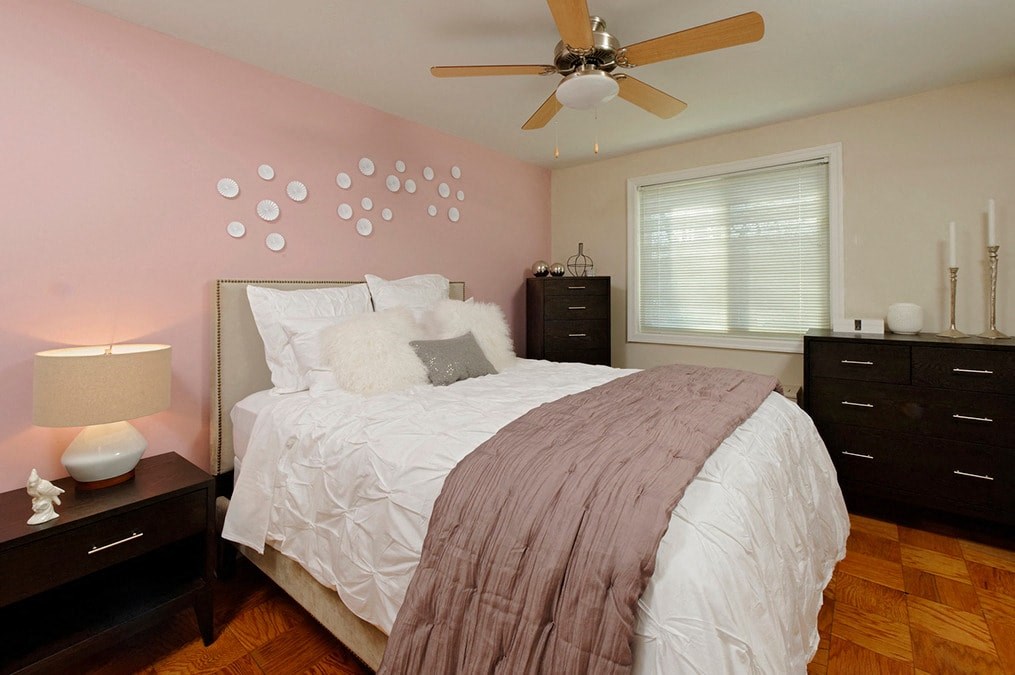 a bedroom with a bed and a ceiling fan