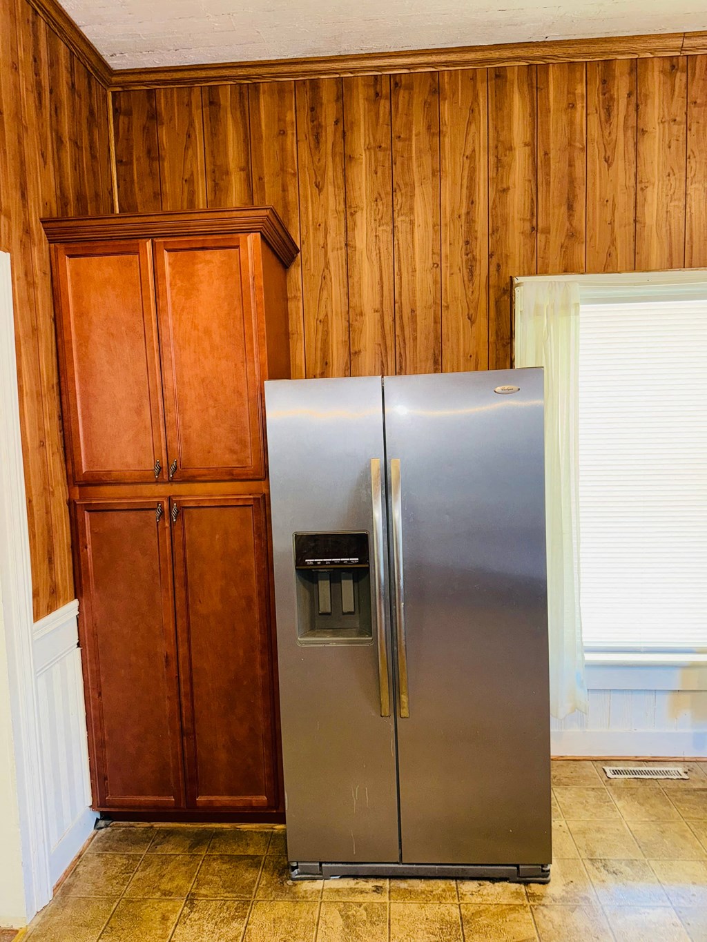 a stainless steel refrigerator in a kitchen next to a cabinet