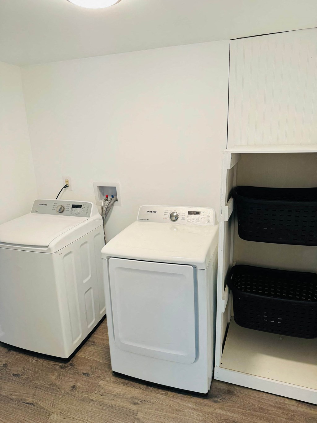 a washer and dryer in a laundry room with a shelf next to them