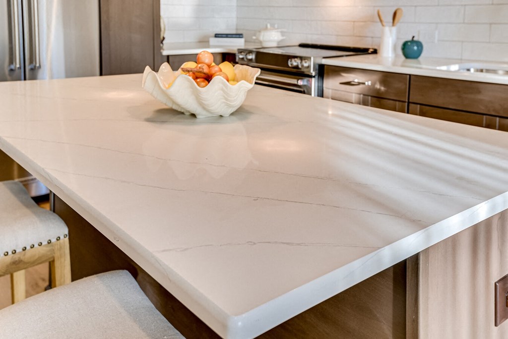 A kitchen counter with a bowl of fruit on it.