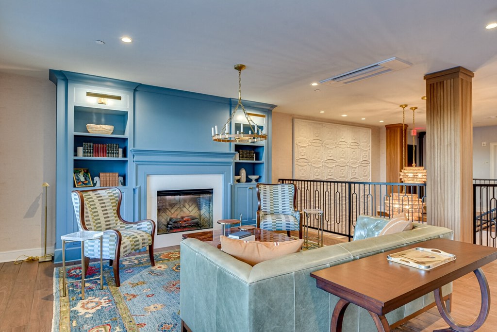 A living room with a fireplace and a blue chair.