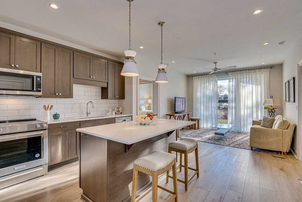 A modern kitchen with a center island and stools.