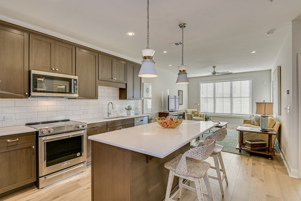 A kitchen with a white island and wooden cabinets.
