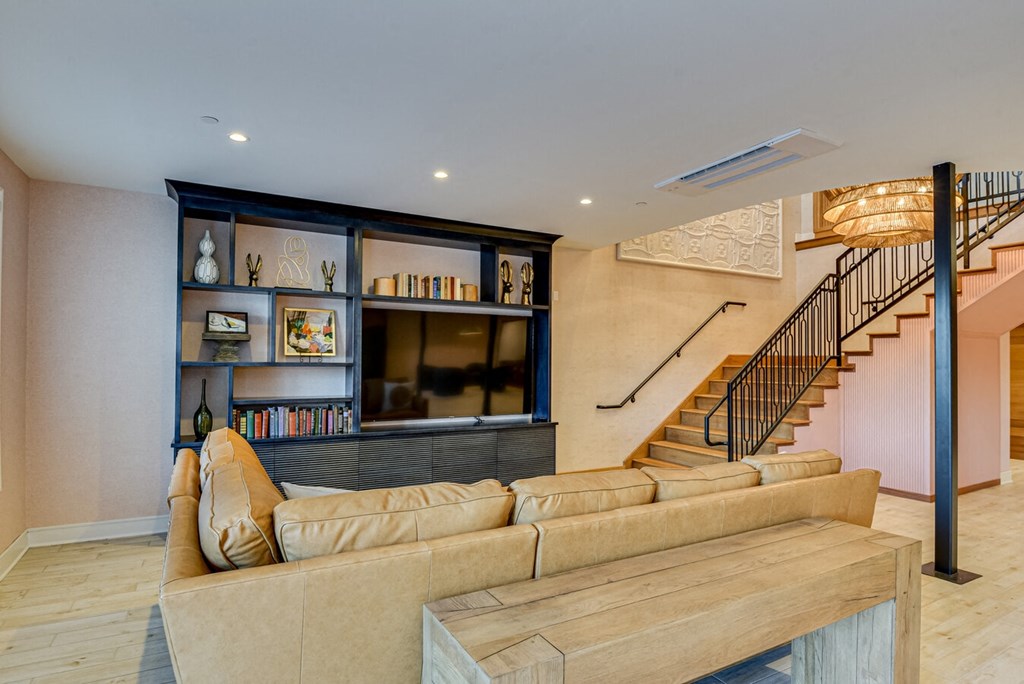 A living room with a staircase and a bookshelf.