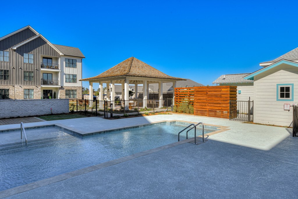 A swimming pool surrounded by a gazebo and a fence.