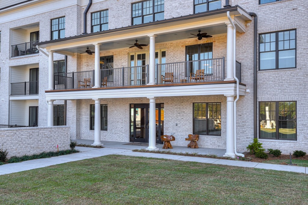 A large white building with a balcony and a patio.