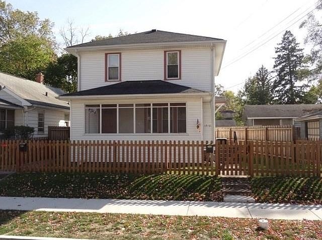 A white house with a brown fence in front.