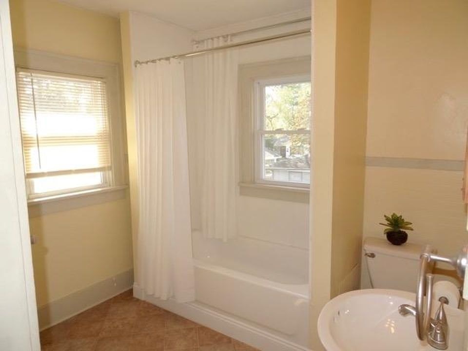 A bathroom with a white tub and sink.