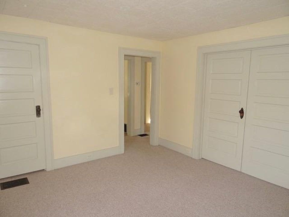 A room with two doors and a carpeted floor.