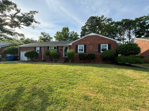 a brick house with a lawn in front of it