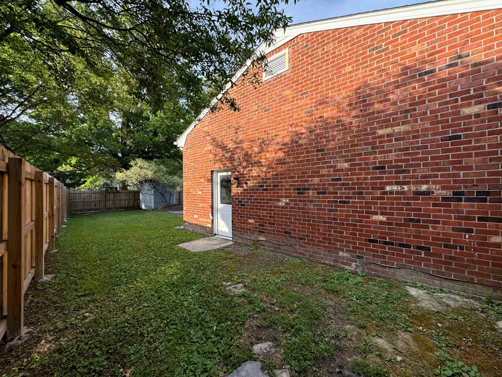 the back of a brick house with a door in it