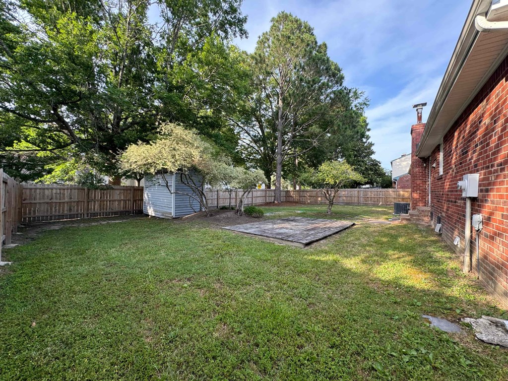 the backyard of a house with a yard and a blue shed
