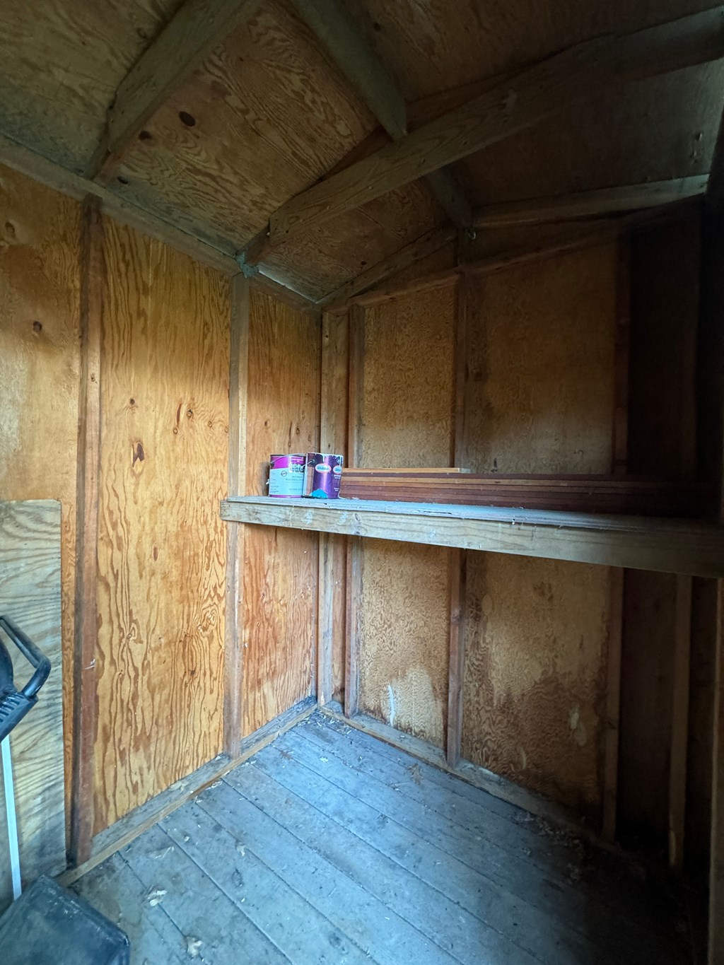 the inside of a wooden cabin with a shelf on the wall