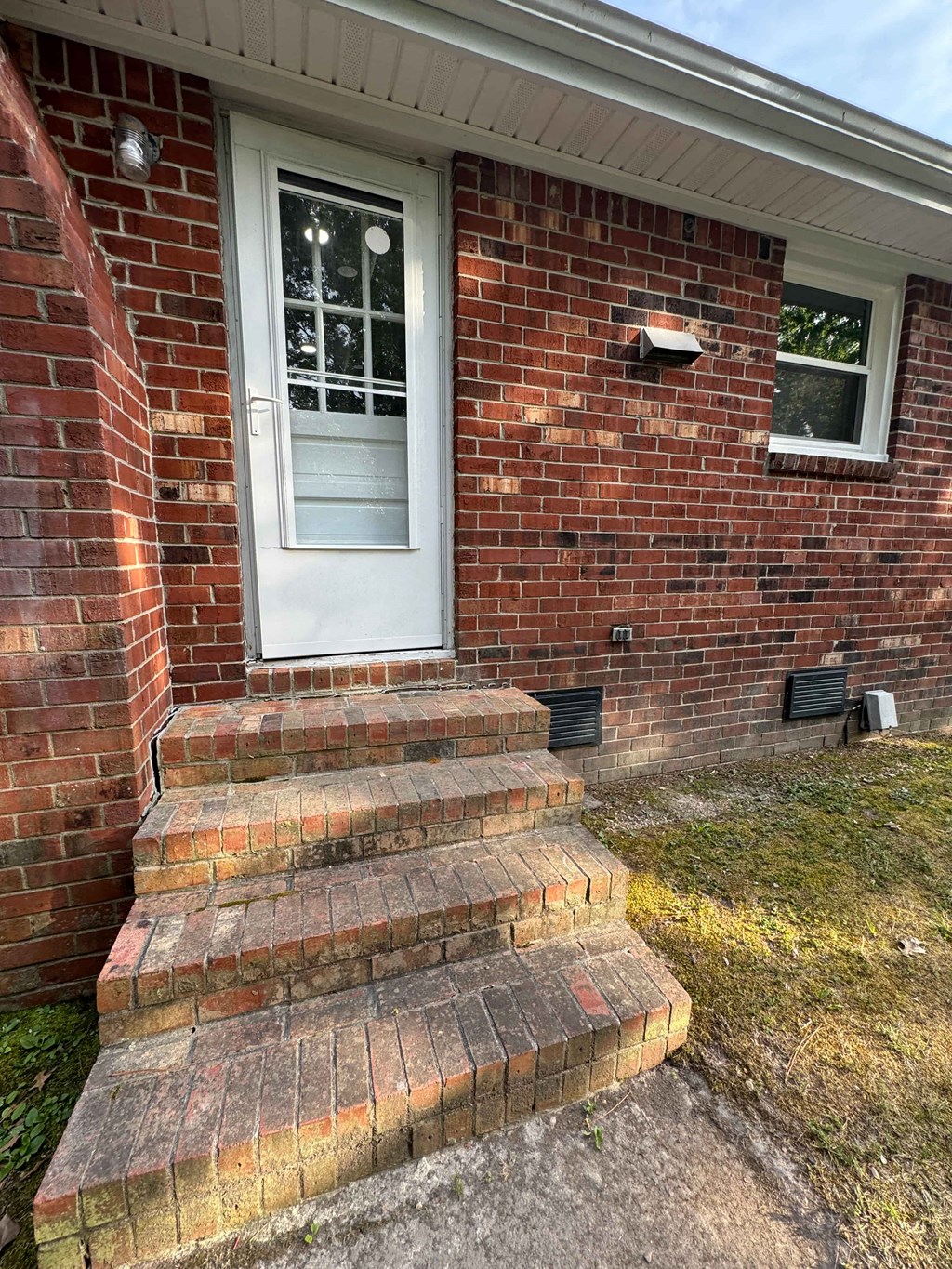 a brick house with steps and a white door