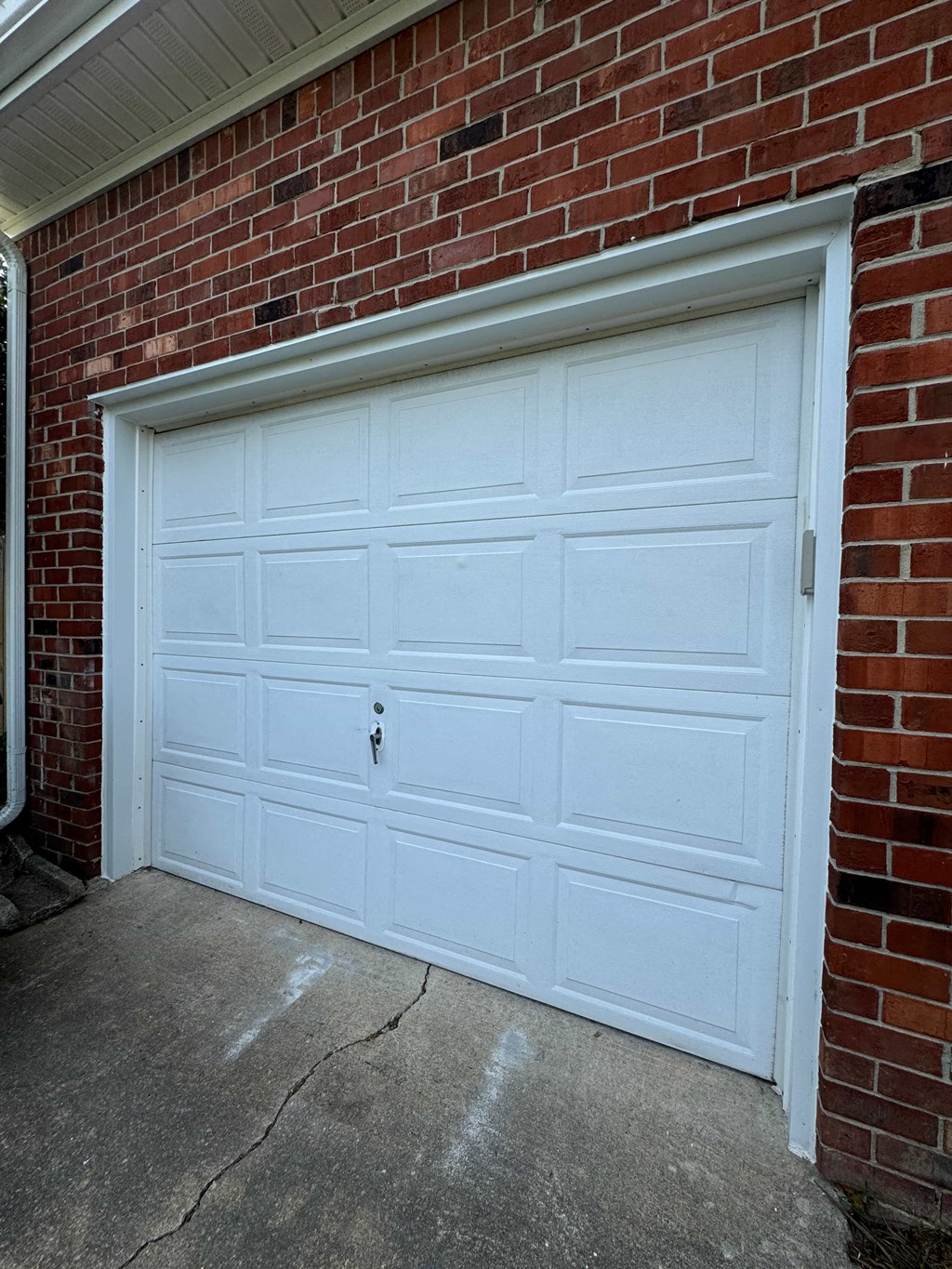 a white garage door on the side of a brick building