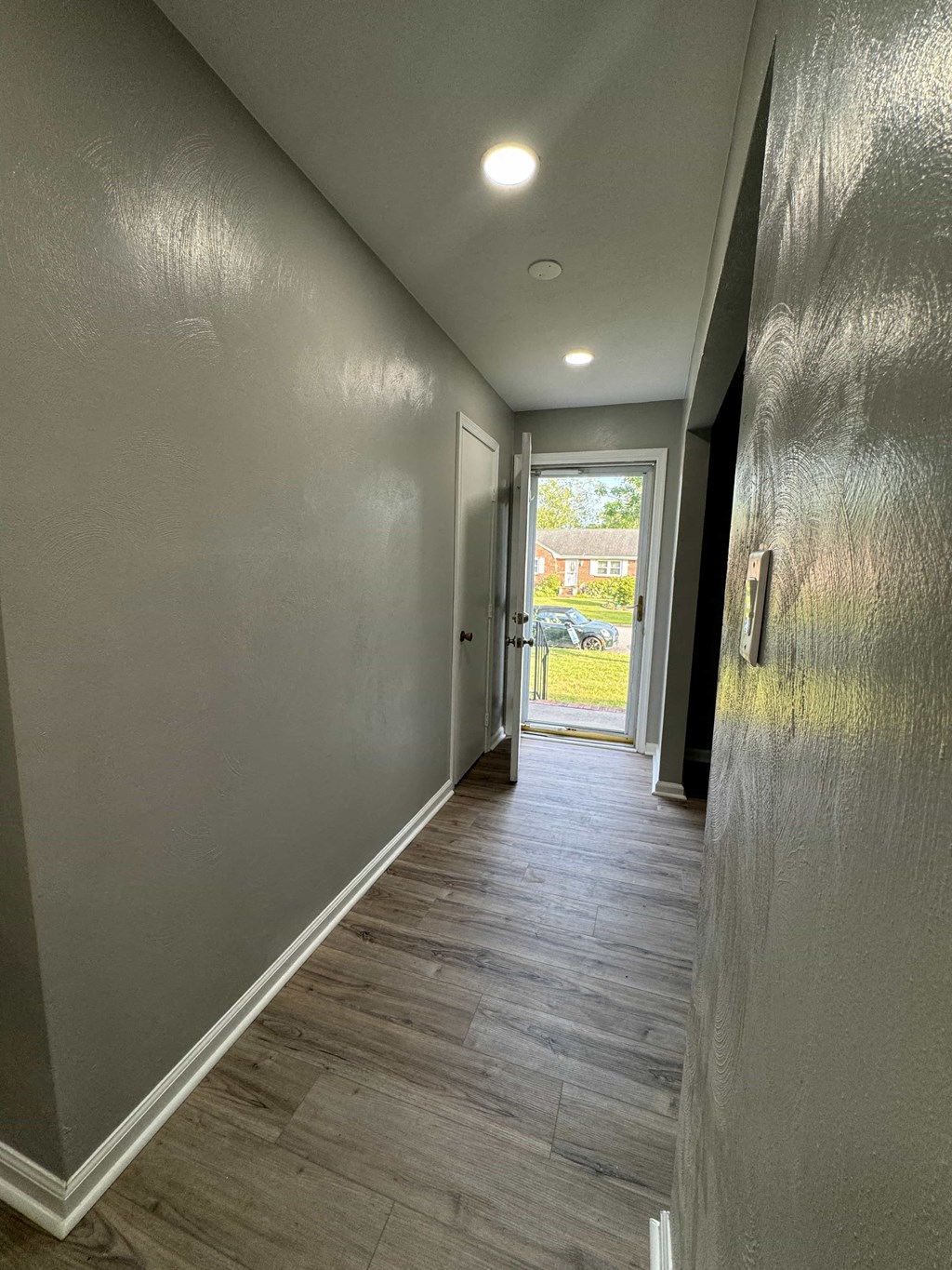 a long hallway with a door to a house