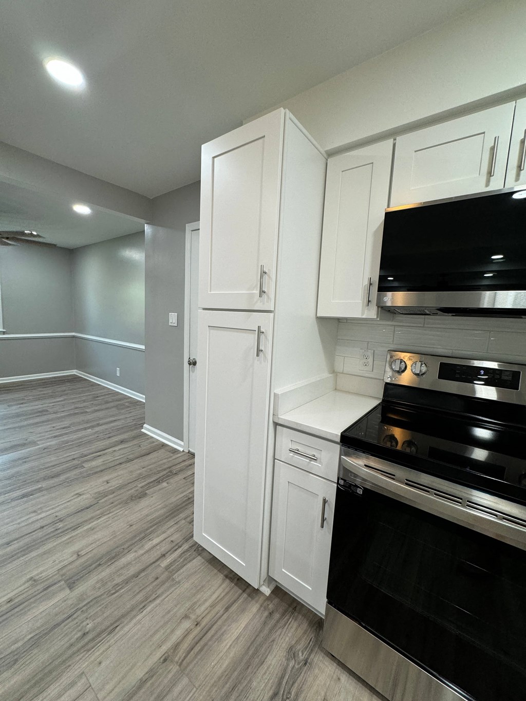 a kitchen with white cabinets and a black stove and oven