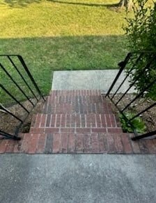 a brick walkway with black wrought iron railings