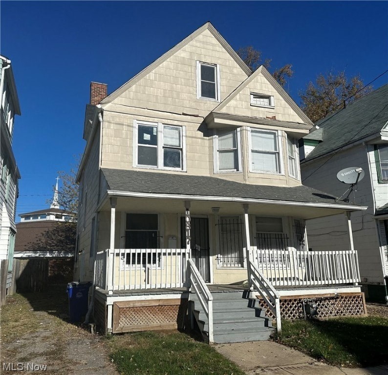 A two-story house with a front porch and a staircase leading to the entrance.