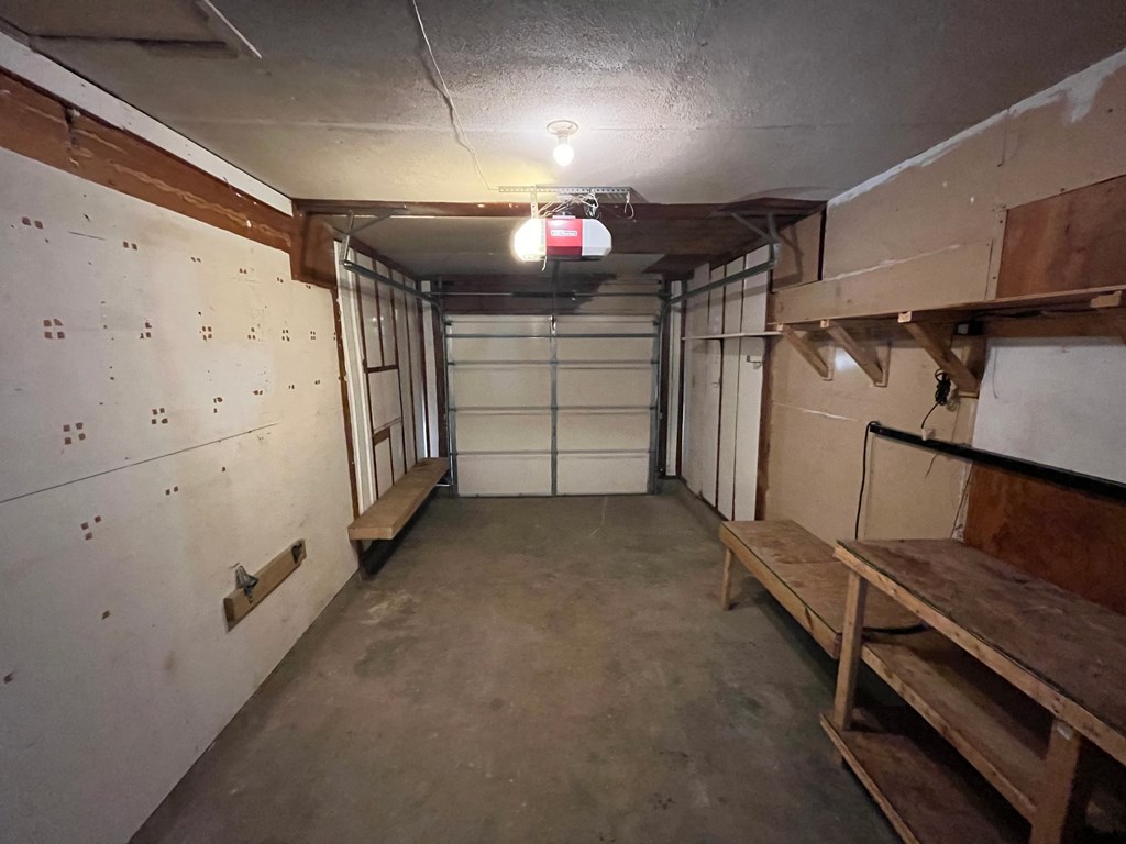 a basement room with a bench and a garage door