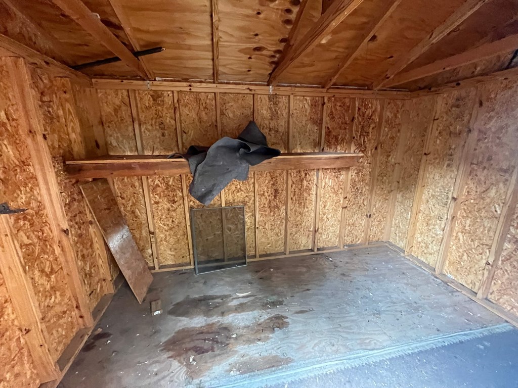 a black cow is hanging from the ceiling of a chicken shed