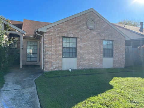 A brick house with a white door and windows.