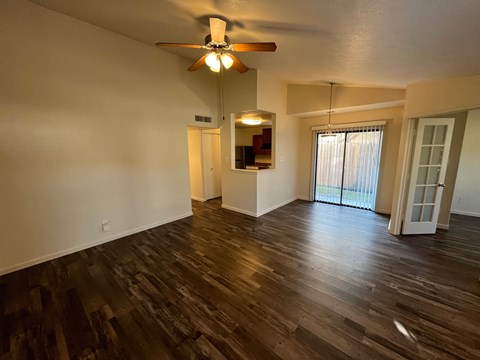 A room with wooden floors and a ceiling fan.