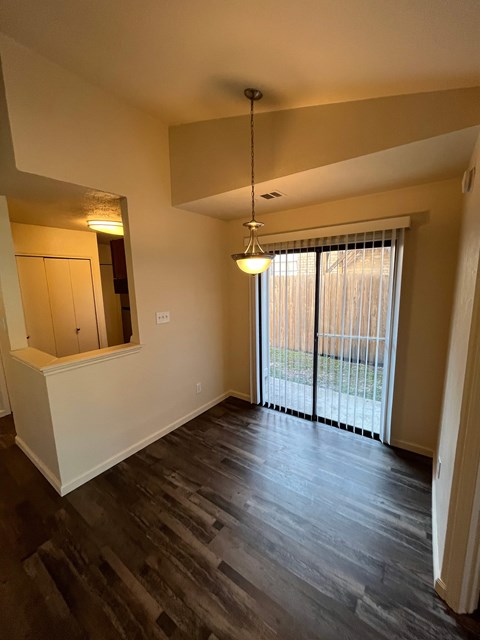 A room with a sliding glass door and a hanging light fixture.