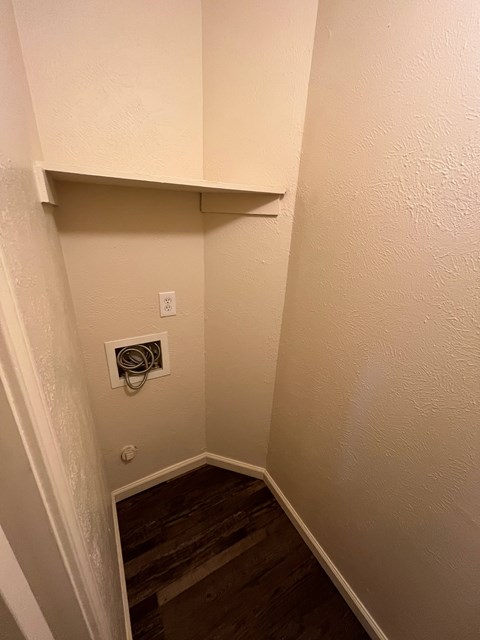 A stairwell with a white wall and a wood staircase.