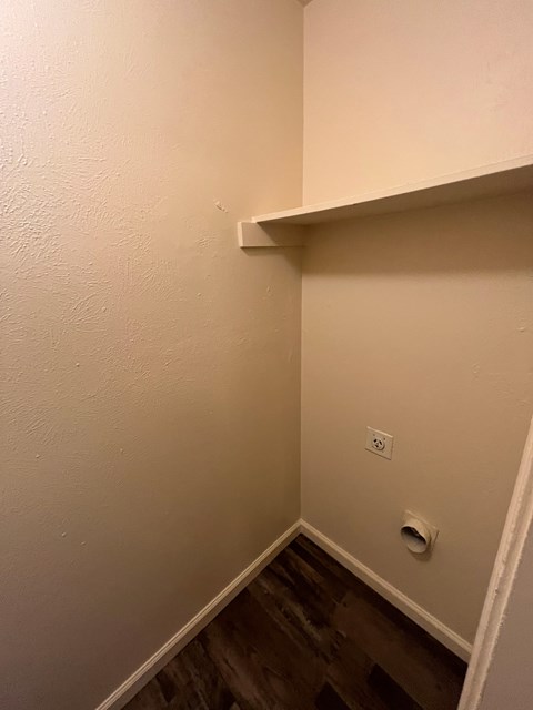 A white wall with a light switch and a vent.