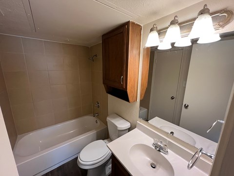 A bathroom with a white toilet, a white sink, and a white bathtub.
