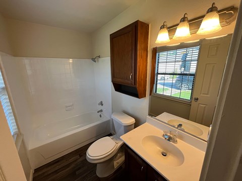 A bathroom with a toilet, sink, and tub.